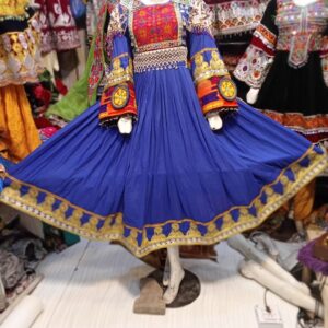 “Mannequin dressed in a vibrant blue traditional Afghani frock featuring intricate embroidery, surrounded by ethnic garments that highlight Afghani embroidery and gemstone jewelry craftsmanship.”
