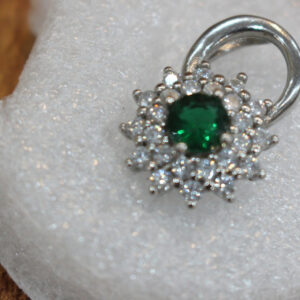 "Green zircon pendant in rhodium-plated silver with white stone floral design, inspired by Afghan heritage and handcrafted for healing and elegance."