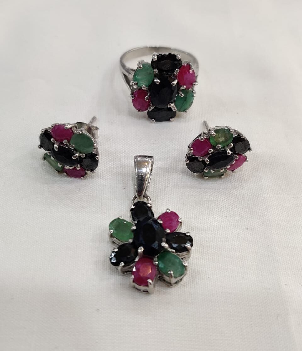 Gem stones jewelry set with silver ring, earrings, and pendant featuring green, pink, and black stones on white background