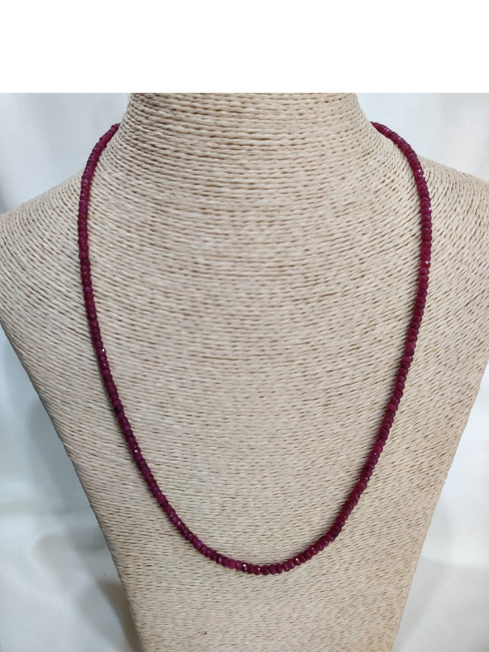 : Elegant ruby stone necklace showcasing faceted beads in deep crimson hues, strung in a continuous loop—an exquisite example of gemstone therapy through Afghan craftsmanship and emotional