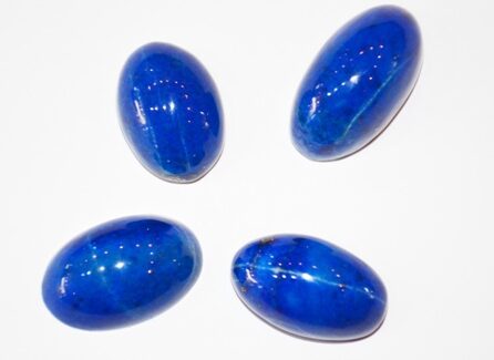 Raw lapis lazuli stone with deep blue hues and golden pyrite flecks, symbolizing truth and emotional healing.