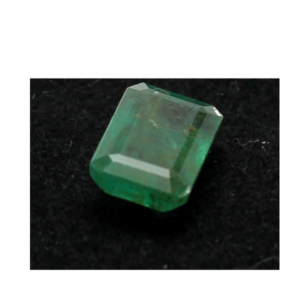 A 3.3 carat emerald gemstone from Swat, hand-cut with precision, resting on soft textured fabric. The stone glows with lush green hues, reflecting the heritage and natural beauty of the Afghan highlands.