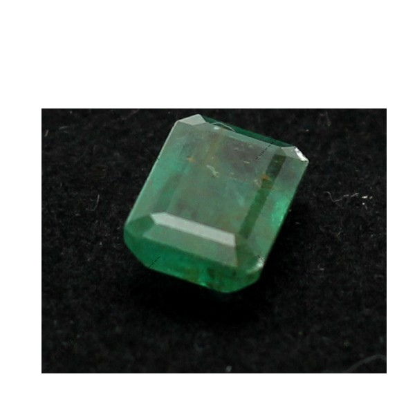 A 3.3 carat emerald gemstone from Swat, hand-cut with precision, resting on soft textured fabric. The stone glows with lush green hues, reflecting the heritage and natural beauty of the Afghan highlands.