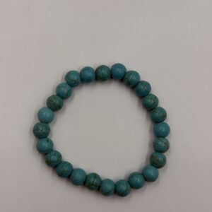 Close-up of a blue agate stone bracelet featuring various shades of blue and white banding on each bead, strung on an elastic cord with an adjustable leather closure.