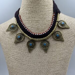 an artisan-crafted necklace from Nepal, showcasing a raw-cut blue turquoise stone set in a polished brass pendant with silver filigree
