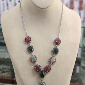Elegant necklace displayed on a beige mannequin, featuring symmetrical clusters of genuine gemstones set in Italian rhodium silver, handcrafted by AfghaniEmbroidery.com..
